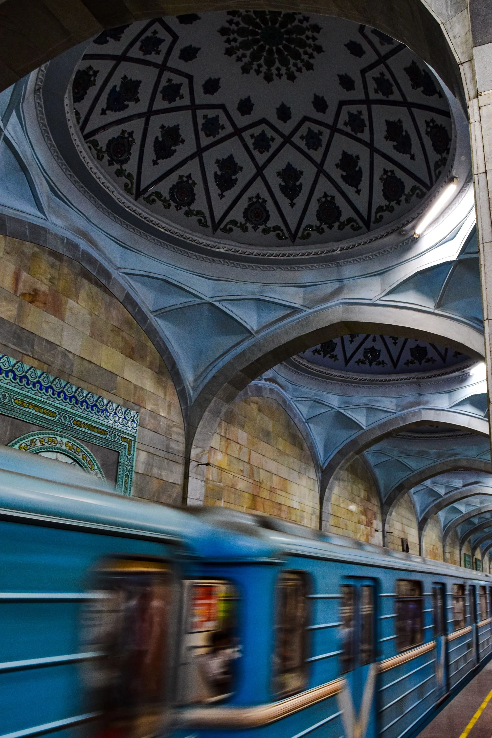 Станция ташкентского метро с расписным куполом и проходящим поездом